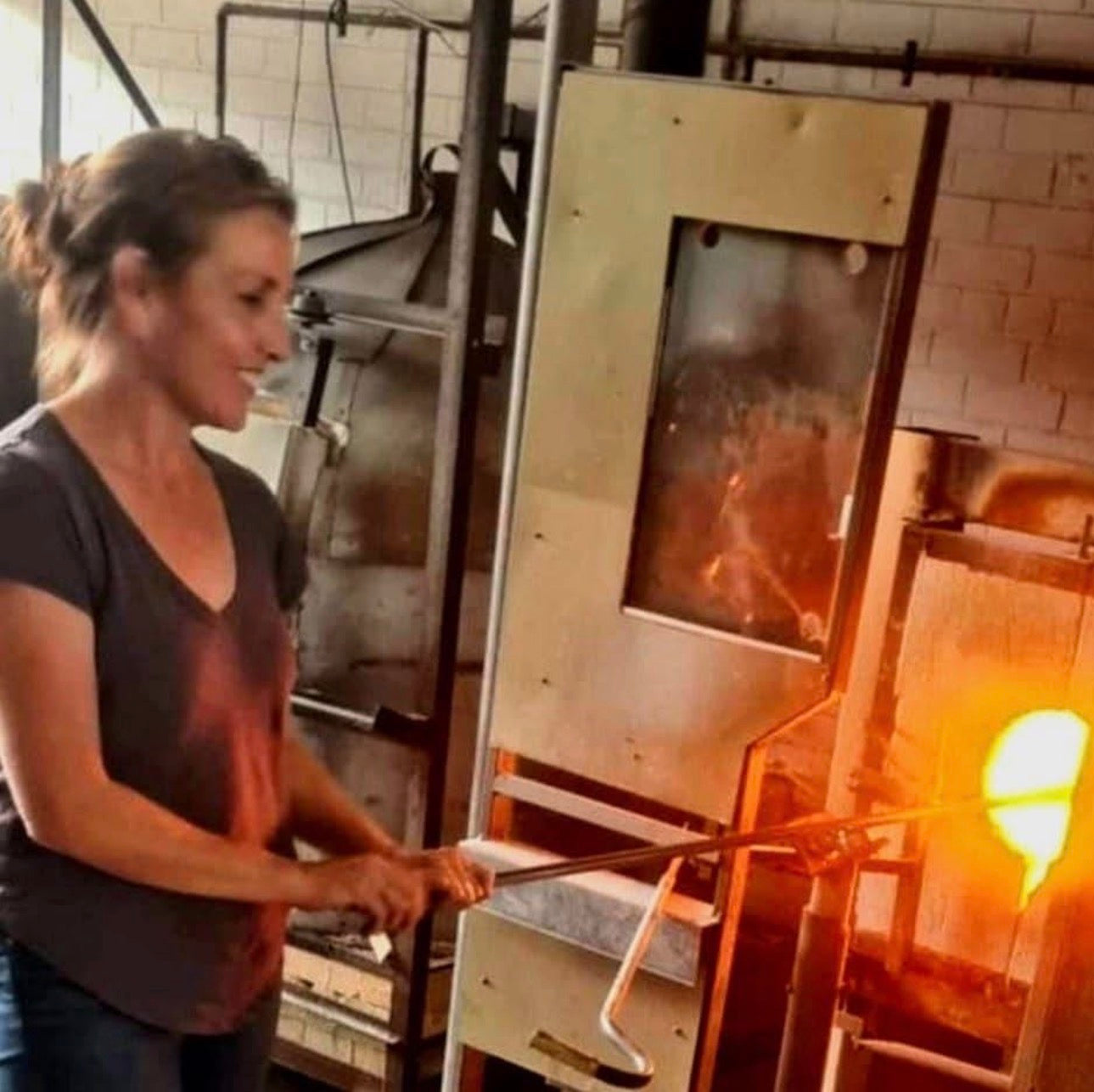 Clementine working with molten glass to make a glass orb